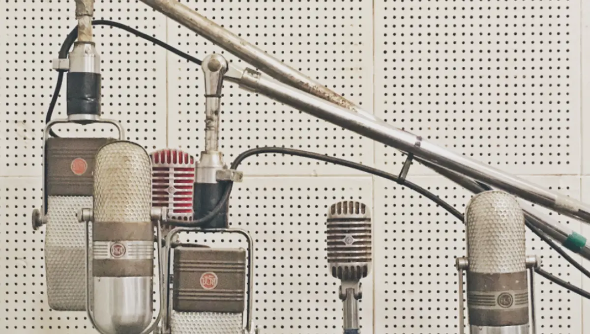 Row of studio microphones in an open recording room